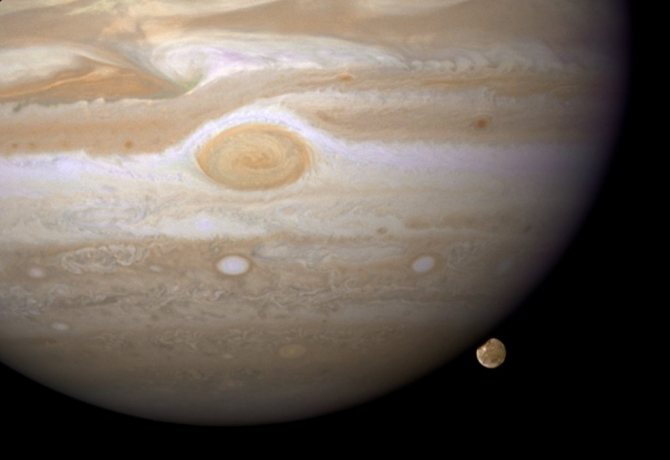 На полноценный проход вокруг Юпитера Ганимед тратит 7 дней. Поскольку его орбита наклонена практически ребром по отношению к Земле, то его можно увидеть только мельком, а потом он прячется за гигантским хозяином. Ганимед, состоящий из камня и льда, это наибольший спутник в нашей системе. По своим размерам он даже превосходит Меркурий. Но рядом с Юпитером кажется грязным снежным комом. Величина планеты настолько необъятная, что на снимке поместилась только часть.