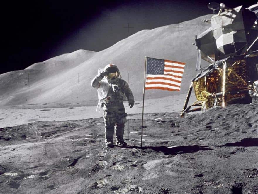 На заднем плане – лунный модуль, а впереди – салютирующий американскому флагу Дейв Скотт из Аполлона-15 после посадки в 1971 году. Это четвертая лунная миссия и первая с ровером
