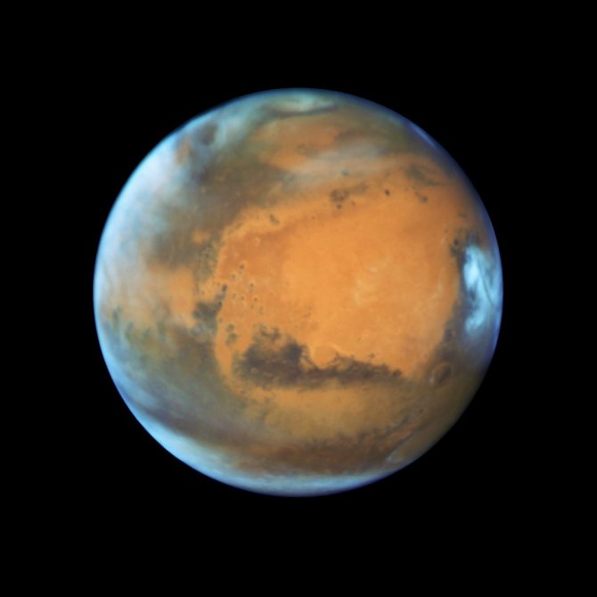 Снимок показывает Марс, наблюдаемый незадолго до оппозиции в 2020 году космическим телескопом Хаббл. Отчетливо заметны некоторые характерные особенности планеты: древний и неактивный щитовидный вулкан Сырт, яркая и овальная равнина Эллада, серьезная эрозия Arabia Terra (в центре), темные черты Sinus Sabaeous и Sinus Meridiani вдоль экватора, а также небольшая южная полярная шапка.